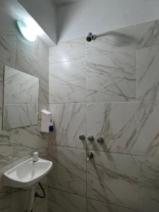 Un baño blanco con lavabo y ducha. en Hospedaje Malvinas, en Alta Gracia