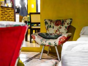 a chair sitting in a room with a yellow wall at Residencial dos Freitas in Jericoacoara