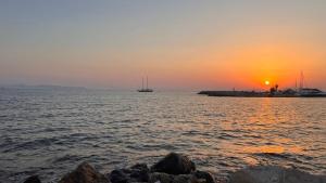 a sunset over a body of water with boats at Beach house in the heart of Athens Riviera in Athens