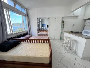 a small room with two beds and a kitchen at Conforto perto do Mar em São Vicente! in São Vicente