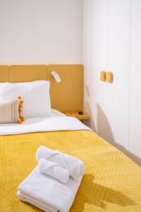 プリシュティナにあるSapling Apartmentのタオルが敷かれたベッドのある寝室