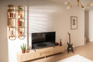 a living room with a flat screen tv on a entertainment center at Sapling Apartment in Prishtinë