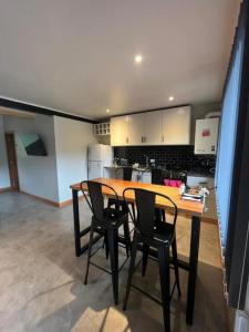 une cuisine avec une table et des chaises dans une pièce dans l'établissement Complejo Pradera Centro, à San Martín de los Andes