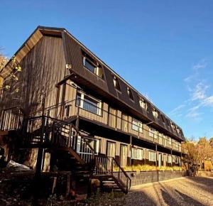 un grand bâtiment en bois avec un escalier qui y mène dans l'établissement Complejo Pradera Centro, à San Martín de los Andes