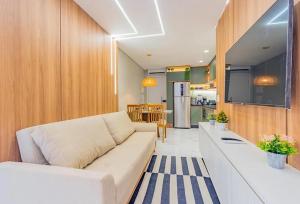 Una sala de estar con un sofá blanco y una cocina. en Atlantis 312: Luxury and Style Porto de Galinhas, en Porto de Galinhas