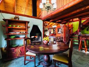 a dining room with a table and a fireplace at Complejo Peuma Hue in Lago Puelo
