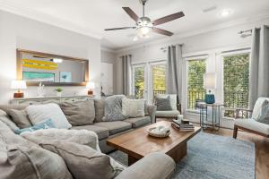 a living room with a couch and a table at Lux Beatles themed beach home, 5 min WALK to Beach + Golf Cart, Dog Friendly! in Destin
