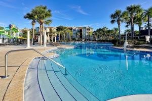 a swimming pool at a resort with palm trees at Windsor Hills Resort - Water Park - Private Heated Plunge Pool - Near Disney in Orlando