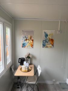 a room with a table and two paintings on the wall at BB Luxury Space in Eltham