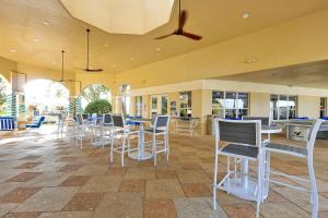 a restaurant with white chairs and tables and windows at Windsor Hills Resort - Water Park - Private Heated Plunge Pool - Near Disney in Orlando