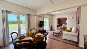 a living room with a table and a couch at Beach house in the heart of Athens Riviera in Athens