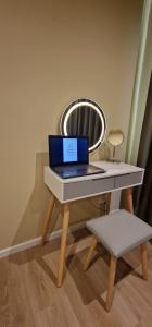 a laptop computer sitting on a table with a stool at Casa Mateo Mediterranes Studio in Bielefeld