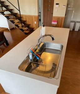 a kitchen sink with a bunch of scissors in it at Eleven Auto Camp Park - Vacation STAY 44752v in Kururi