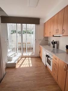 a kitchen with wooden cabinets and a large window at Ideal modern bungalow MA1 in Torrevieja
