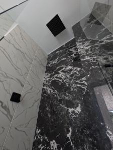 a bathroom with a marble floor and a ceiling at Finca Las palmas Guatape in Guatapé