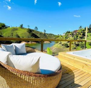 a wicker chair sitting on a deck next to a hot tub at Finca Las palmas Guatape in Guatapé