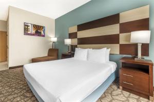 a hotel room with a large bed and a chair at Best Western Joliet Inn & Suites in Joliet