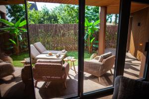 a patio with chairs and a table and glass doors at Spa lodge africain in Arques