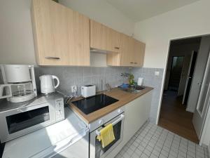 a small kitchen with a sink and a microwave at Akram Appartement VI - Naturnah mit Ausblick in Hildesheim