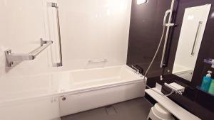 a bathroom with a bath tub and a sink at Ｓｗｉｍｍｙ Ｉｎｎ Ｏｎａｇａｗａ - Vacation STAY 31602v in Onagawa