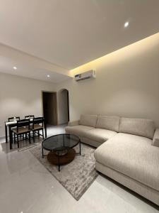 a living room with a couch and a table at Onyx F62-2BHK modern classy furnished home with balcony in Muscat