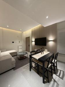 a living room with a table and a couch at Onyx F62-2BHK modern classy furnished home with balcony in Muscat
