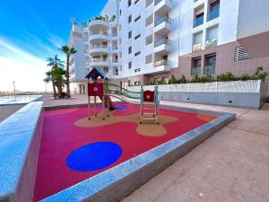a playground in front of a apartment building at La perla del Atlántico in Casablanca