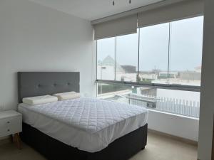 a white bedroom with a bed and large windows at Acogedora casa de playa para la familia y amigos in San Antonio +38 photos