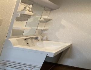 a bathroom with a white sink and a mirror at MONJUNO FUKUCHI - Vacation STAY 26041v in Kamikishida