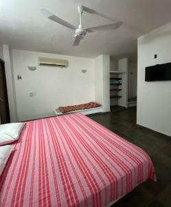 Un dormitorio con una cama grande con ventilador de techo. en Costa Ayala, en Los Ayala