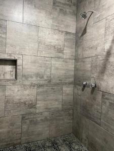 a bathroom with a shower with a stone wall at Costa Ayala casa para 18 personas a cuadra y media de la playa in Los Ayala