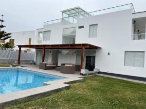 a villa with a swimming pool and a house at Acogedora casa de playa para la familia y amigos in San Antonio