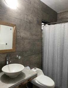 Un baño con lavabo, inodoro y ducha. en Costa Ayala, en Los Ayala