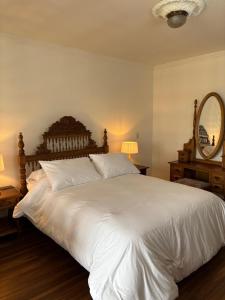 a bedroom with a large white bed and a mirror at Hotel Puntalarga in Nobsa +4 photos