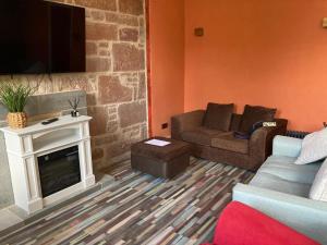 a living room with a couch and a fireplace at The Tartan Sheep in Kilmarnock