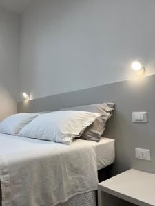 a bedroom with a bed with white sheets and pillows at Pertichetti Living in Foligno