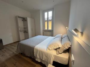 a bedroom with a bed with white sheets and a window at Pertichetti Living in Foligno
