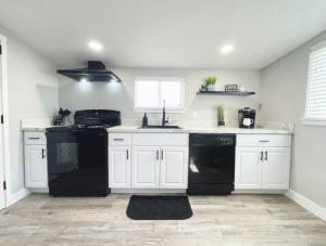 a kitchen with white cabinets and a black dishwasher at Cozy Home in Visalia
