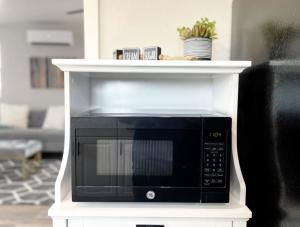 a microwave on a white shelf in a living room at Cozy Home in Visalia