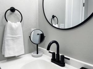 a bathroom sink with a mirror and a towel at Cozy Home in Visalia