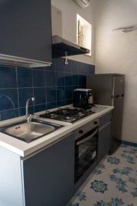 a kitchen with a sink and a stove and a refrigerator at Appartamento in centro - Blu Mare in Gaeta