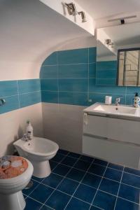 a blue and white bathroom with a toilet and sink at Appartamento in centro - Blu Mare in Gaeta +11 photos