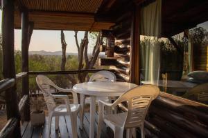 a table and chairs on the porch of a cabin at Posada de Nono in Nono