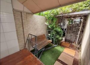 a patio with a wooden bench and green grass at Casa Lagos do Frances in Marechal Deodoro