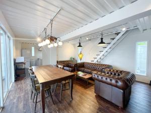 a living room with a table and leather furniture at Vamos Villa Tokunoshima - Vacation STAY 19370v in San