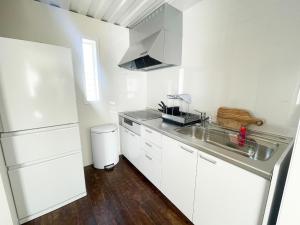 a white kitchen with a sink and a refrigerator at Vamos Villa Tokunoshima - Vacation STAY 19370v in San +14 photos