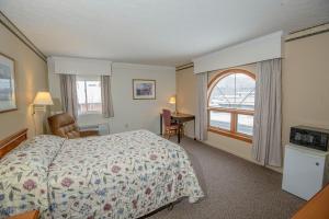 Una habitación de hotel con una cama y una ventana. en Westgate Inn, en Coudersport