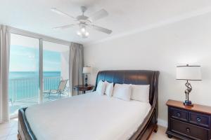 a bedroom with a bed and a balcony with the ocean at Palazzo 1401 in Panama City Beach