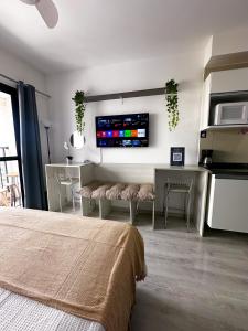una camera da letto con un letto e una TV a parete di Apto Alto da Luz - 16º Andar a San Paolo