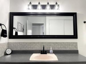 a bathroom sink with a large mirror above it at Lovely Home Central Coalinga in Coalinga +18 photos